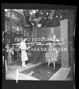 Pessoas a depositar flores junto a monumento comemorativo Moreira da Silva em frente à Cooperativ...