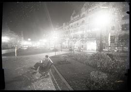 Homem sentado na praça. Vista nocturna