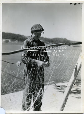 Pescador consertando a rede